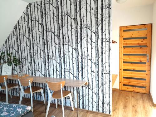 a dining room with a table and some trees mural at Sowinka in Lutowiska