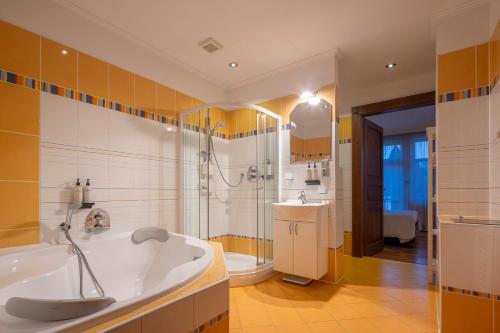 a bathroom with a tub and a shower and a sink at Pytloun Villa Liberec in Liberec