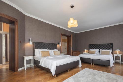 - une chambre avec 2 lits et 2 tables dans l'établissement Pytloun Villa Liberec, à Liberec