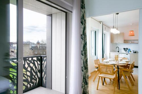Il dispose d'une cuisine et d'une salle à manger avec un balcon et une table. dans l'établissement Majestic & Idyllic Parisian Flat - Champs-Elysées, à Paris