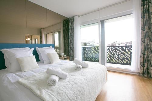 une chambre avec un grand lit avec des serviettes dessus dans l'établissement Majestic & Idyllic Parisian Flat - Champs-Elysées, à Paris