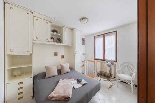 een slaapkamer met een bed, een stoel en een raam bij Residence Giardino 3 by Wonderful Italy in Soiano del Lago