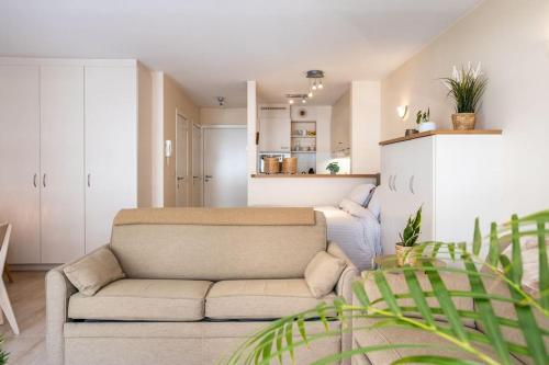 a living room with a couch and a kitchen at Top studio Knokke bij zeedijk! in Knokke-Heist