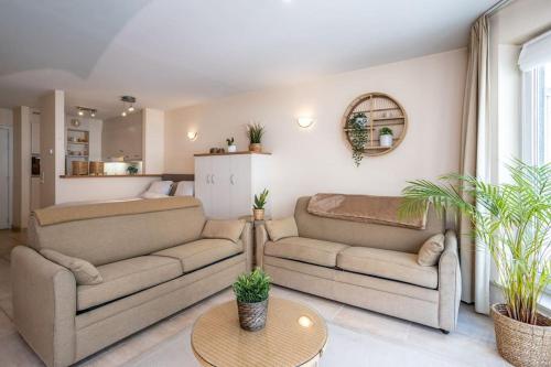 a living room with two couches and a table at Top studio Knokke bij zeedijk! in Knokke-Heist