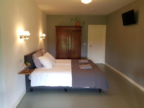 1 dormitorio con 1 cama grande y cabecero de madera en Houterhoeve, en Swalmen