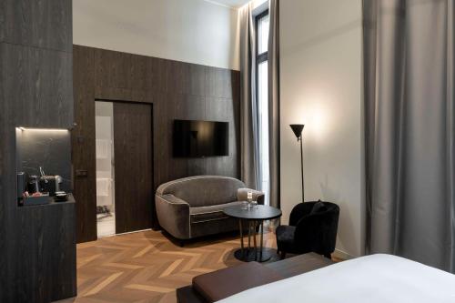 a hotel room with a bed and a chair and a table at Radisson Collection Hotel, Palazzo Touring Club Milan in Milan