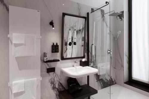 a white bathroom with a sink and a shower at Radisson Collection Hotel, Palazzo Touring Club Milan in Milan