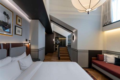 a bedroom with a bed and a couch at Radisson Collection Hotel, Palazzo Touring Club Milan in Milan