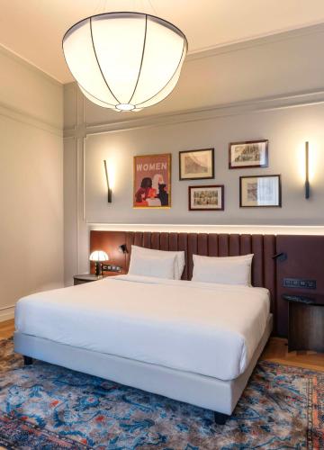 a bedroom with a large white bed and a chandelier at Radisson Collection Hotel, Palazzo Touring Club Milan in Milan