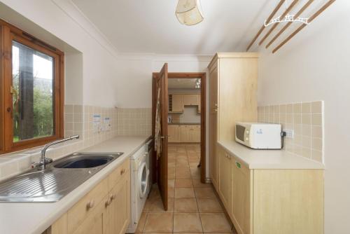 a kitchen with a sink and a microwave at Godolphin in Wadebridge