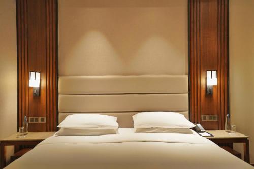 a bedroom with a large bed with two pillows at Hyatt Centric Rajpur Road Dehradun in Dehradun