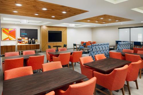 a dining room with tables and chairs and a screen at Holiday Inn Express and Suites Wheeling by IHG in Triadelphia