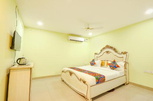 a bedroom with a bed and a flat screen tv at FabHotel Prime JVS Beauty Green Resorts in Venkatāpur