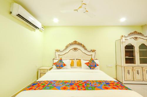 a bedroom with a large bed with a colorful blanket at FabHotel Prime JVS Beauty Green Resorts in Venkatāpur