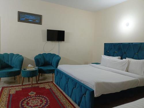 イスラマバードにあるLuxury Moon Guest Houseのベッドルーム1室(青いベッド1台、青い椅子2脚付)