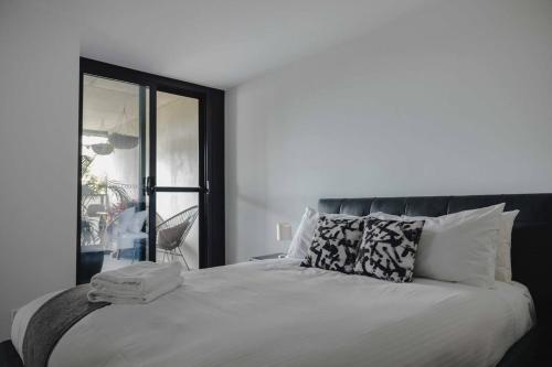 um quarto com uma grande cama branca e uma janela em Central 1-Bed with Pool Sauna Gym and Parking em Camberra