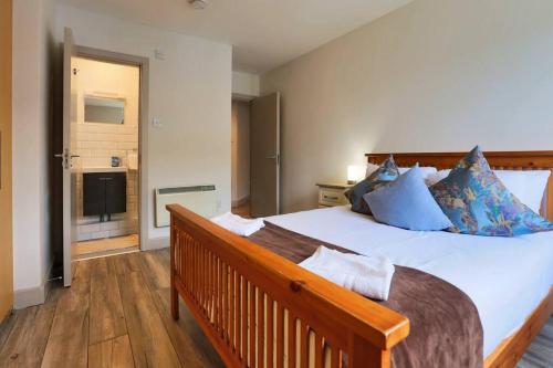 um quarto com uma grande cama branca com almofadas azuis em Modern 3 bedroom apartment with city river views em Dublin