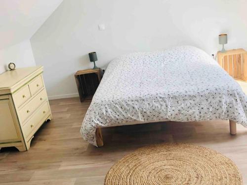 a bedroom with a bed and a dresser and a rug at Appartement duplex cosy in Cormicy