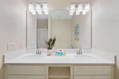 a bathroom with two sinks and a large mirror at 3141 Paradox Circle 406 in Kissimmee