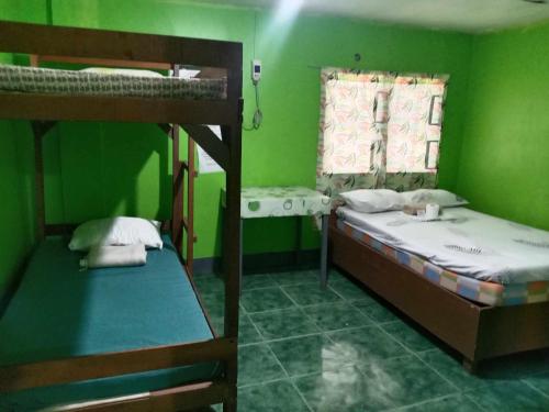 a room with two bunk beds and a window at Bella's Beach Resort (A) in Bauang