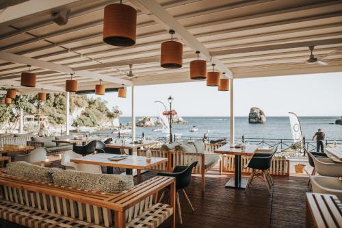 a restaurant on the beach with tables and chairs at Bianco Resort in Parga