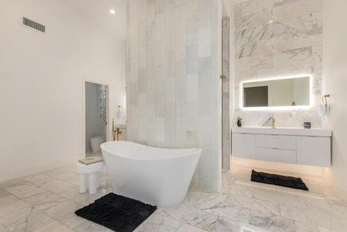 biała łazienka z wanną i umywalką w obiekcie Anderson LUX Estate Private Bar&Pool Sleeps 12 w mieście Phoenix
