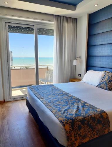 a bedroom with a bed and a view of the ocean at Hotel Concord - Nel cuore di Riccione in Riccione