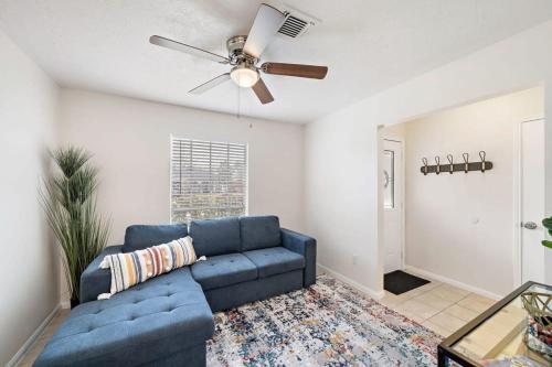 a living room with a blue couch and a ceiling fan at Covered Back Patio Covered Parking Game Room WIFI Smart TV's every room Washer & Dryer in Pasadena
