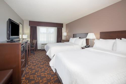 a hotel room with two beds and a flat screen tv at Holiday Inn Express & Suites Yankton by IHG in Yankton