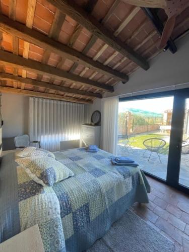 a bedroom with a bed and a large window at Casa Rural Can Titus in L’ Esquirol