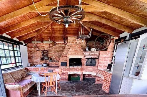 a living room with a brick fireplace and a table at Agropa Garden in Bistriţa