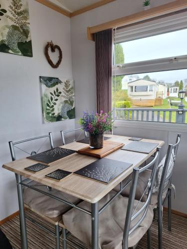 a dining room table with chairs and a window at Three Peaks View. in Clitheroe