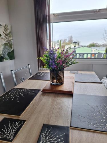 a table with a vase of flowers on top of it at Three Peaks View. in Clitheroe