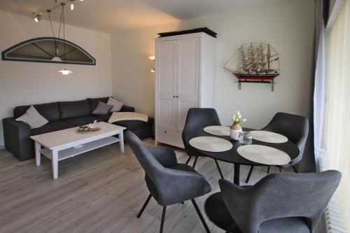 a living room with a couch and a table and chairs at Gro_e Stra_e 19_ Whg_ 1 in Wyk auf Föhr