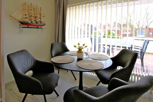 a room with a table and chairs and a ship on the wall at Gro_e Stra_e 19_ Whg_ 1 in Wyk auf Föhr