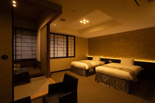 a hotel room with two beds and a window at Kikunoya in Miyajima