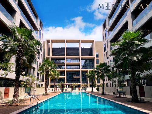 a swimming pool in front of a building with palm trees at City Walk Building 2B - Al Wasl, Jumeirah - Mint Stay in Dubai
