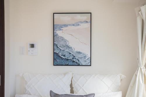 a picture hanging on a white wall above a couch at Walk to Nishi-Nippori/Sendagi/Nippori sta. DBoY in Tokyo