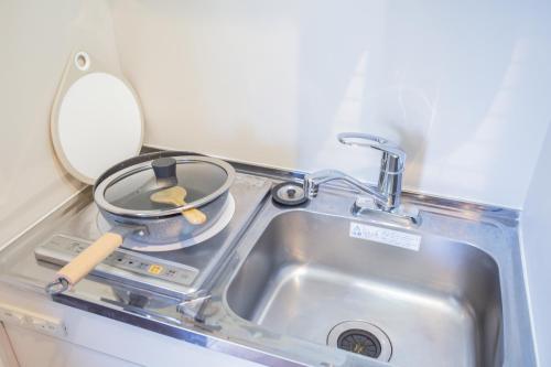 a kitchen sink with a frying pan and a mirror at Walk to Nishi-Nippori/Sendagi/Nippori sta. DBoY in Tokyo