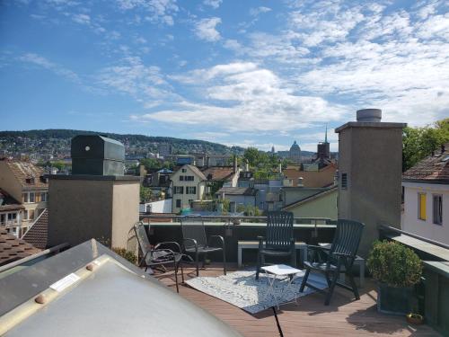 a balcony with chairs and a table on a roof at ROOFTOP with stunning views in Zurich