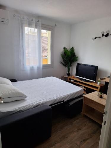 une chambre avec un lit et une télévision à écran plat dans l'établissement Golfe-Juan port, à Vallauris