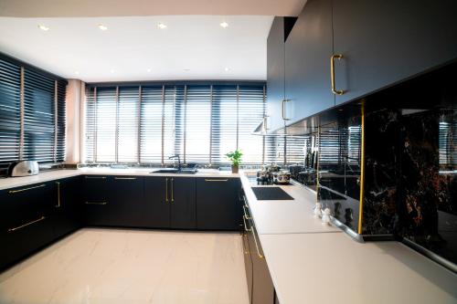 a kitchen with black cabinets and a large window at AuraLux in Agia Triada
