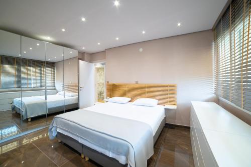 - une chambre avec 2 lits et un miroir dans l'établissement AuraLux, à Agia Triada