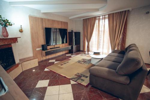 a living room with a couch and a television at Apart4you Hotel in Chişinău