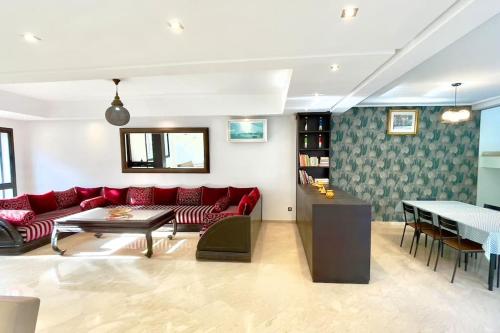 a living room with a red couch and a table at Luxury villa with private pool in Casablanca