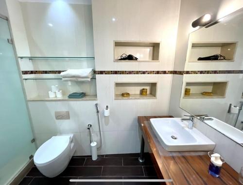 a white bathroom with a sink and a toilet at Luxury villa with private pool in Casablanca