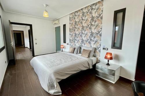 een slaapkamer met een groot wit bed met een muur bij Luxury villa with private pool in Casablanca