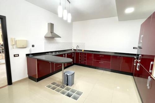 una cocina con armarios rojos y una mesa. en Luxury villa with private pool, en Casablanca