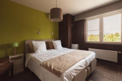 a bedroom with a large bed and a window at Guesthouse Amfora in Poperinge