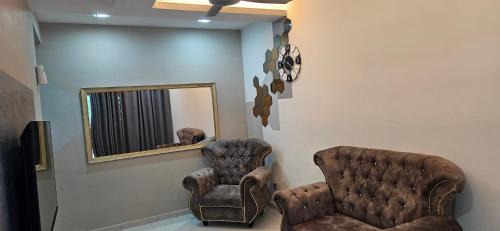 two chairs in a waiting room with a mirror at TELUK INTAN LANDED LUXURY HOMESTAY 3BEDROOM in Teluk Intan